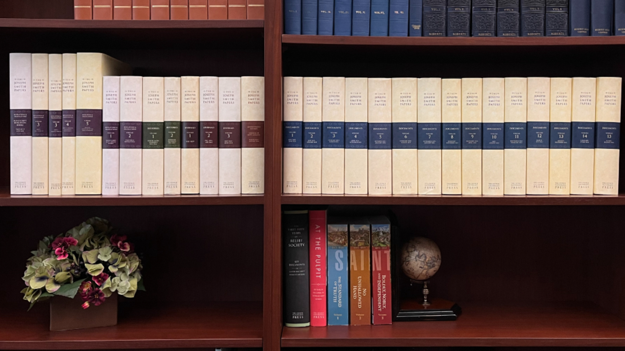 The complete 27-volume set of the Joseph Smith Papers displayed on a bookshelf — 18,822 pages and 7,452,072 words of primary-source documents from the Church Historian's Press (2001–2023).
