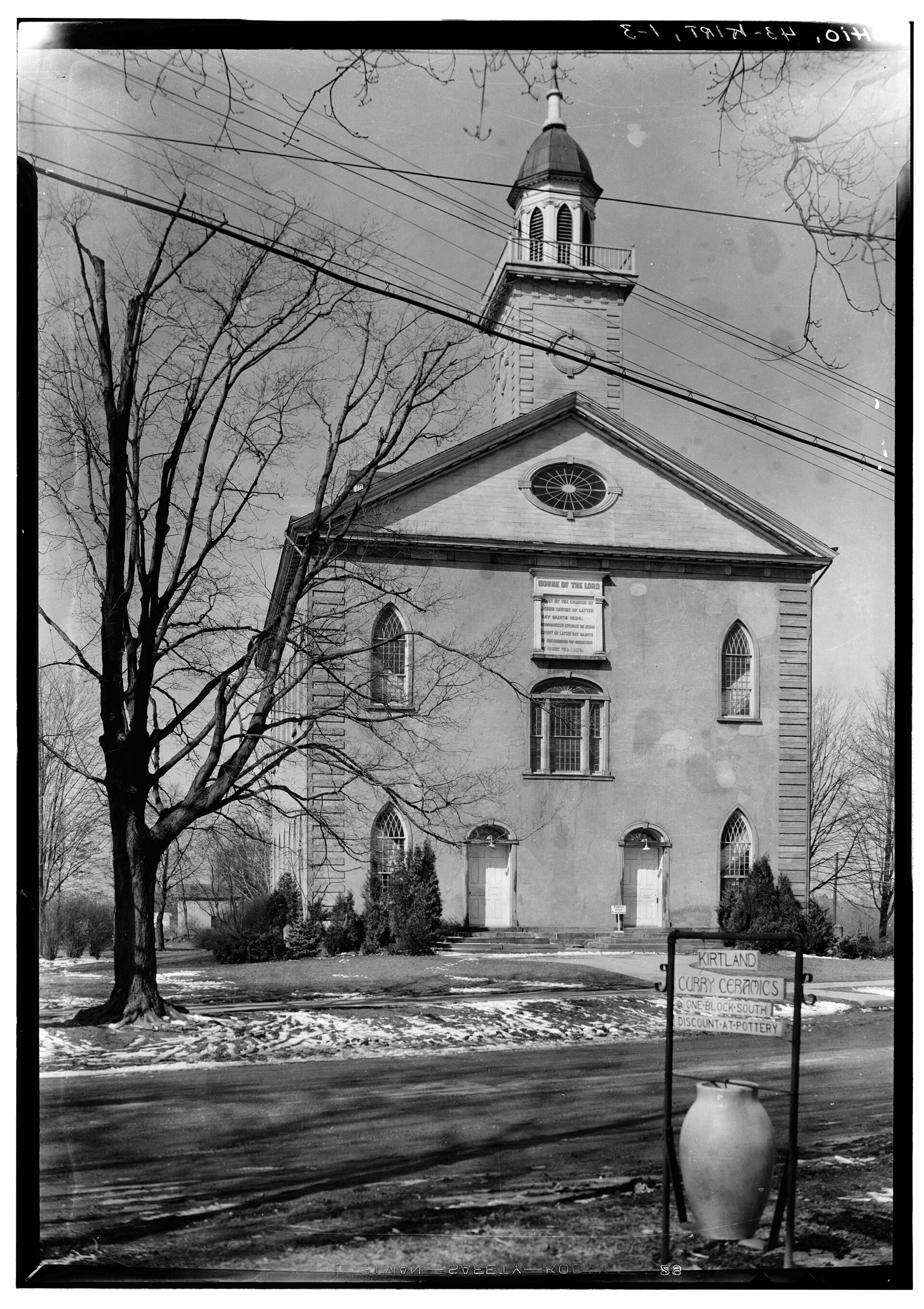 1934 Historic American Buildings Survey black-and-white photograph of the Kirtland Temple east elevation; the inscribed tablet 'HOUSE OF THE LORD / BUILT BY THE CHURCH OF THE / LATTER DAY SAINTS. A.D. 1834' is visible centered between the round window and the second-floor windows.