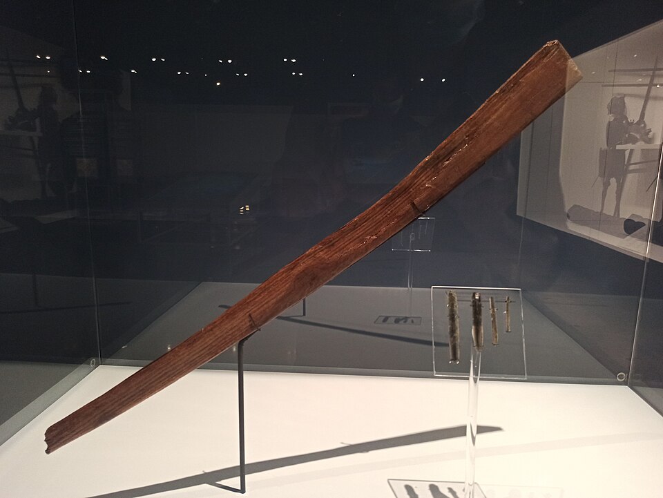Photograph of the San Marcos macuahuitl — an 83-cm hardwood Aztec-style sword with a curved profile, excavated in Mexico City and possibly the only surviving pre-Columbian example, now at the Museo del Templo Mayor