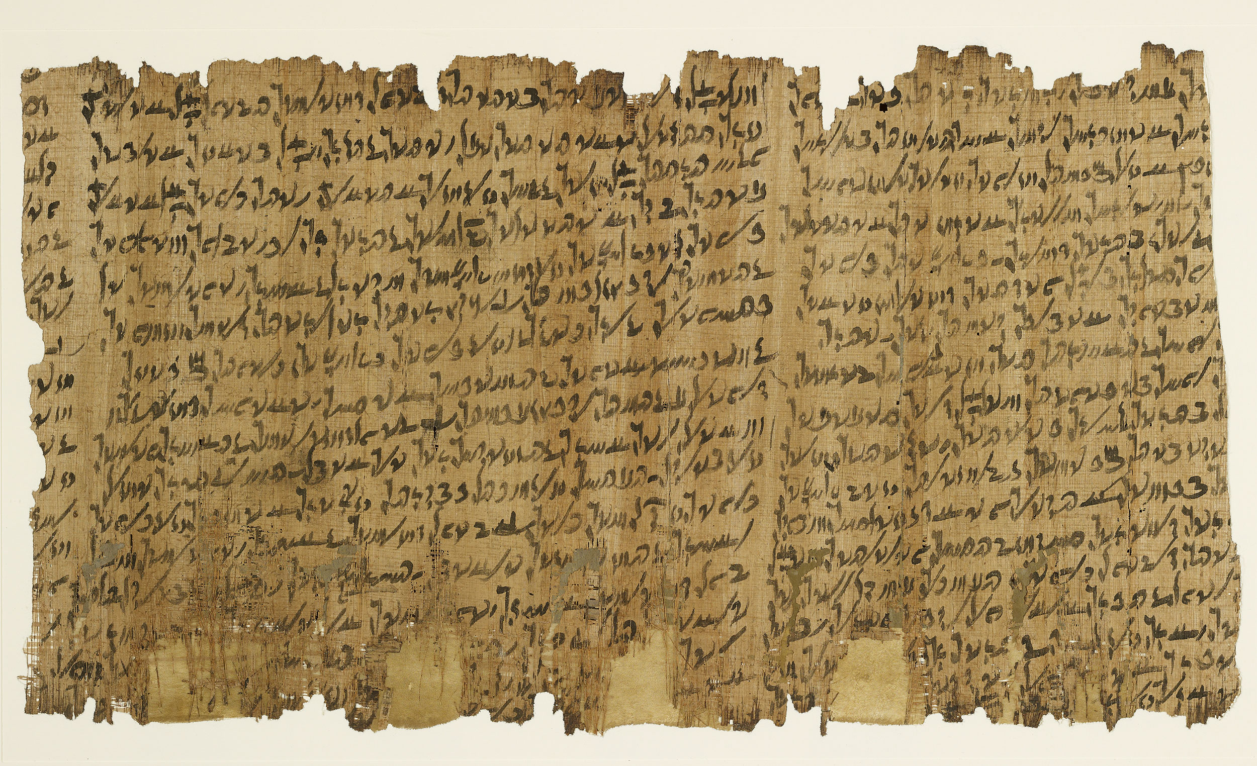 Photograph of a fragment of Papyrus Amherst 63, showing four columns of cursive Egyptian demotic script written in dark brown ink on weathered tan papyrus, with characteristic horizontal fibers visible.